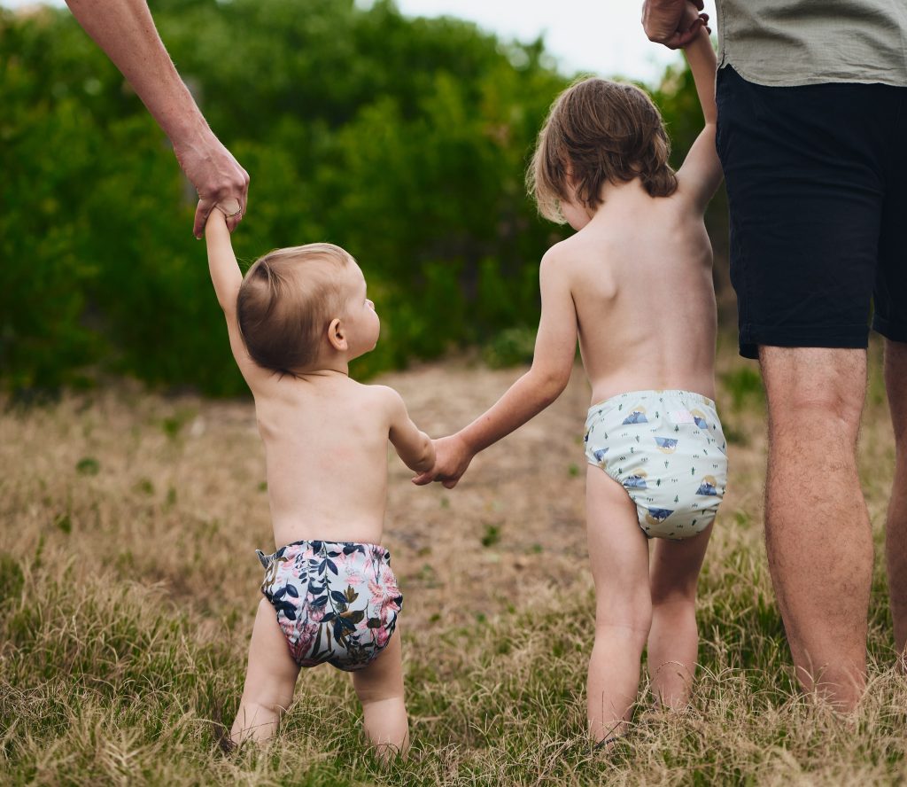 two children holding hands in cloth nappies