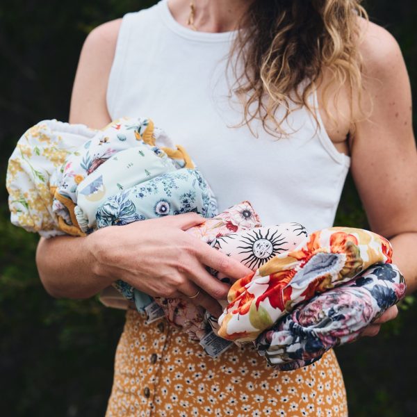 Woman holding a range of cloth nappies for hire